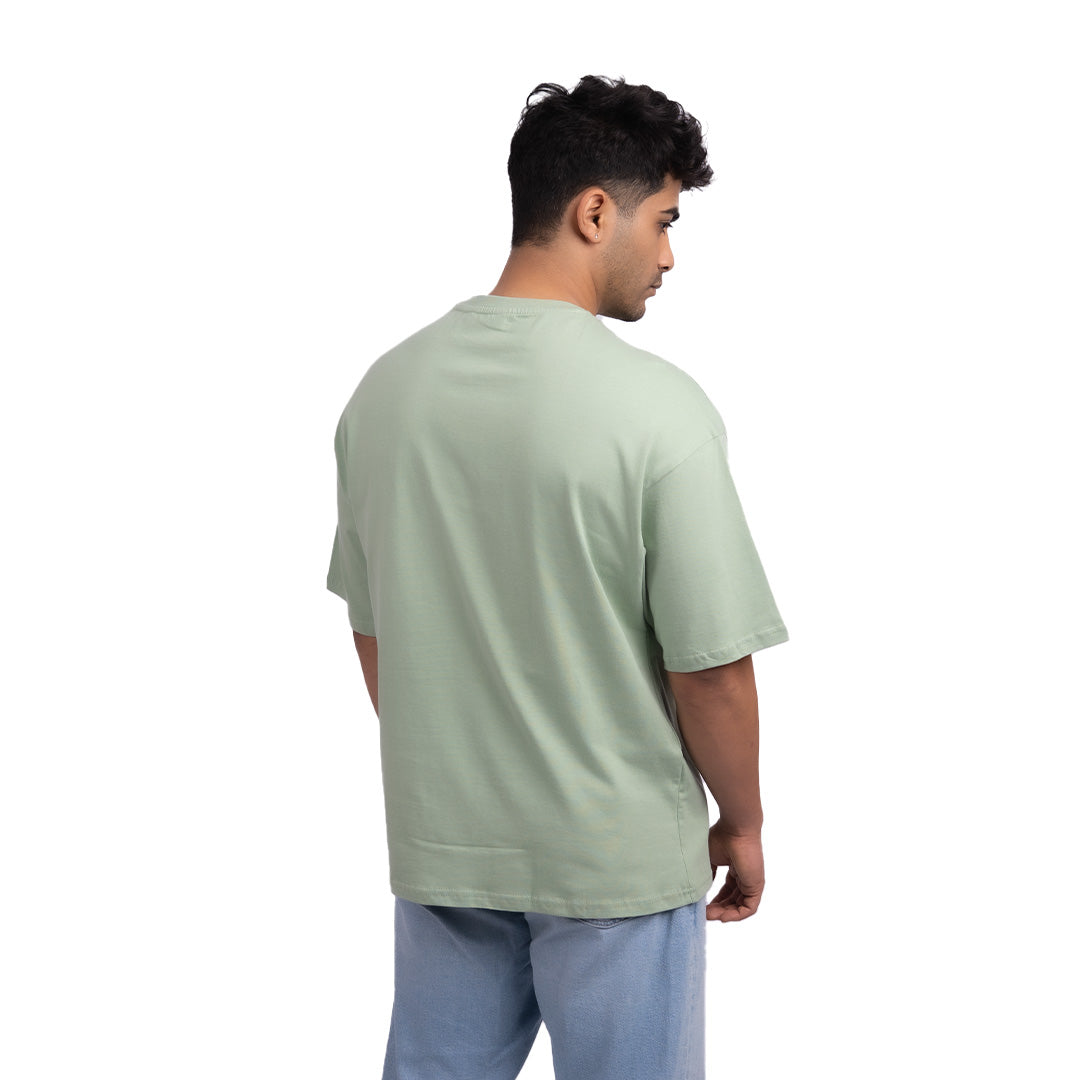 Teal oversized t-shirt angled view – bold oversized tee with a clean design, ideal for confident styling and effortless layering.