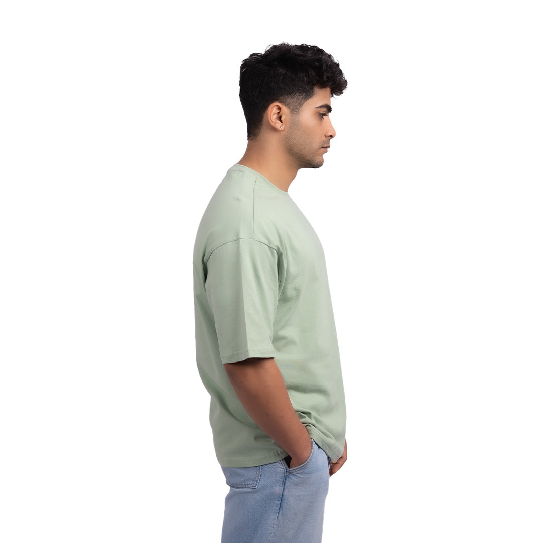 Unisex oversized teal t-shirt side view – breathable oversized tee with a premium cotton blend and a contemporary loose fit.